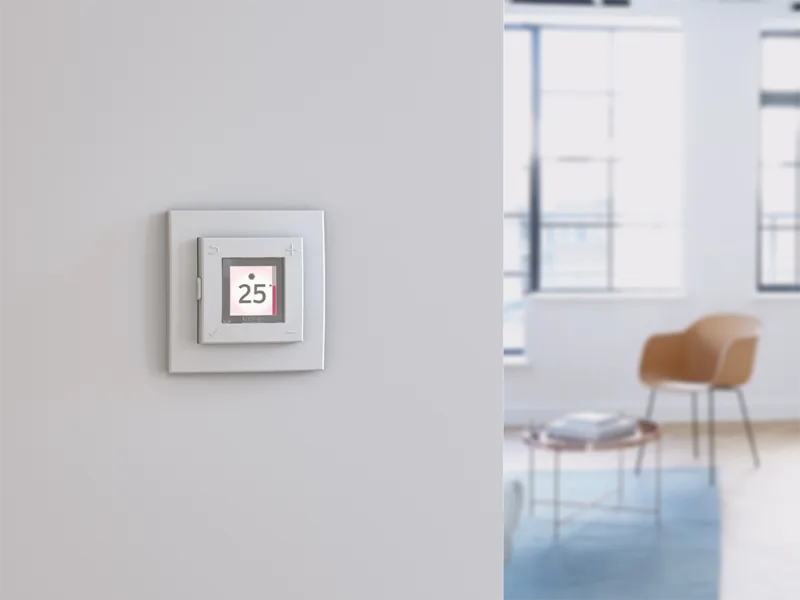Digital termostat på vegg viser 25 grader